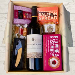 gift box featuring wine, crackers and cherries
