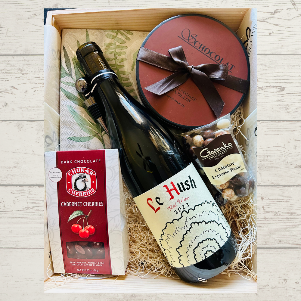 A bottle of wine and chocolate items in box